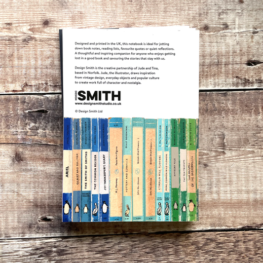 Notebook with colorful design on a wooden surface, featuring Design Smith branding.