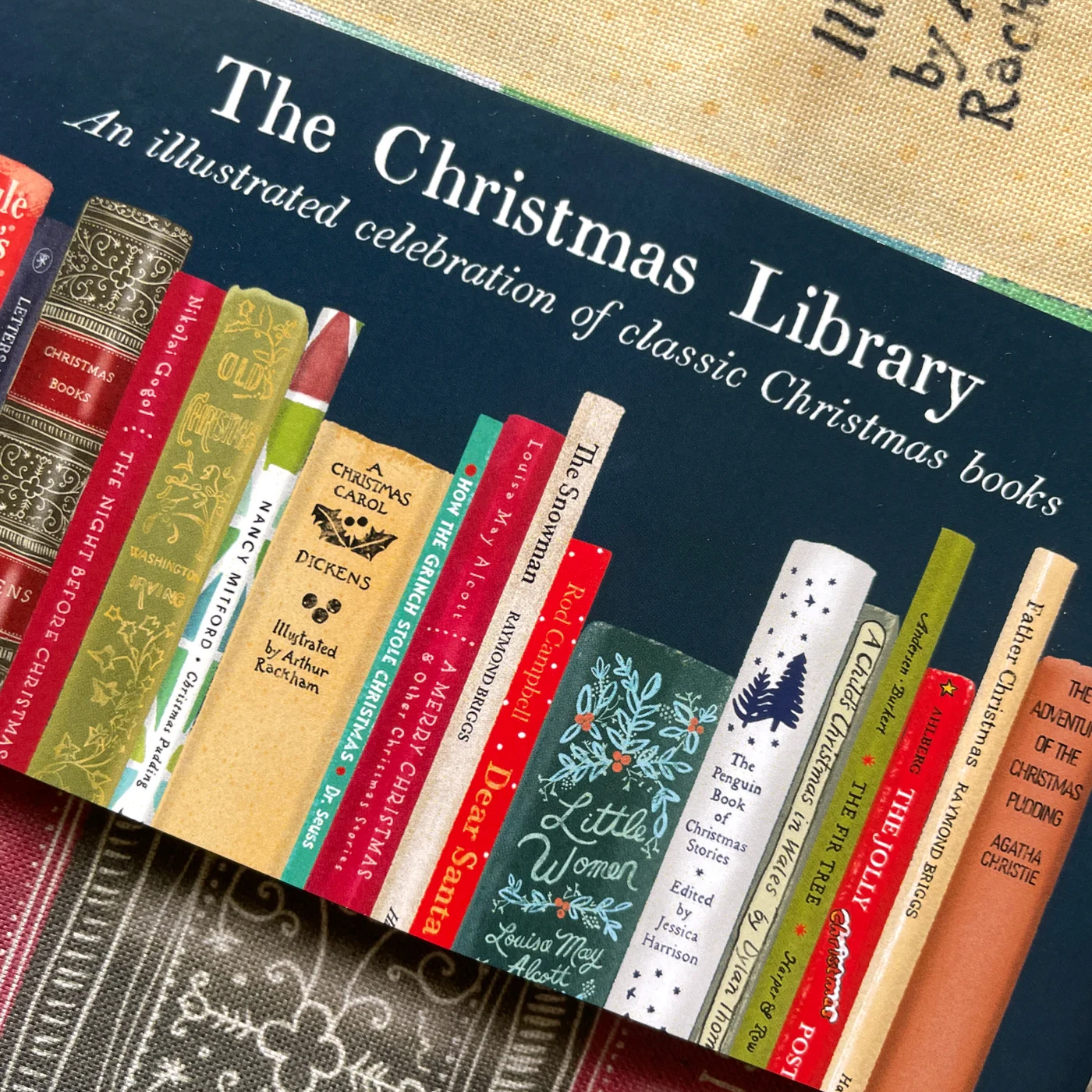 Book cover of 'The Christmas Library' with illustrated book spines on a textured background