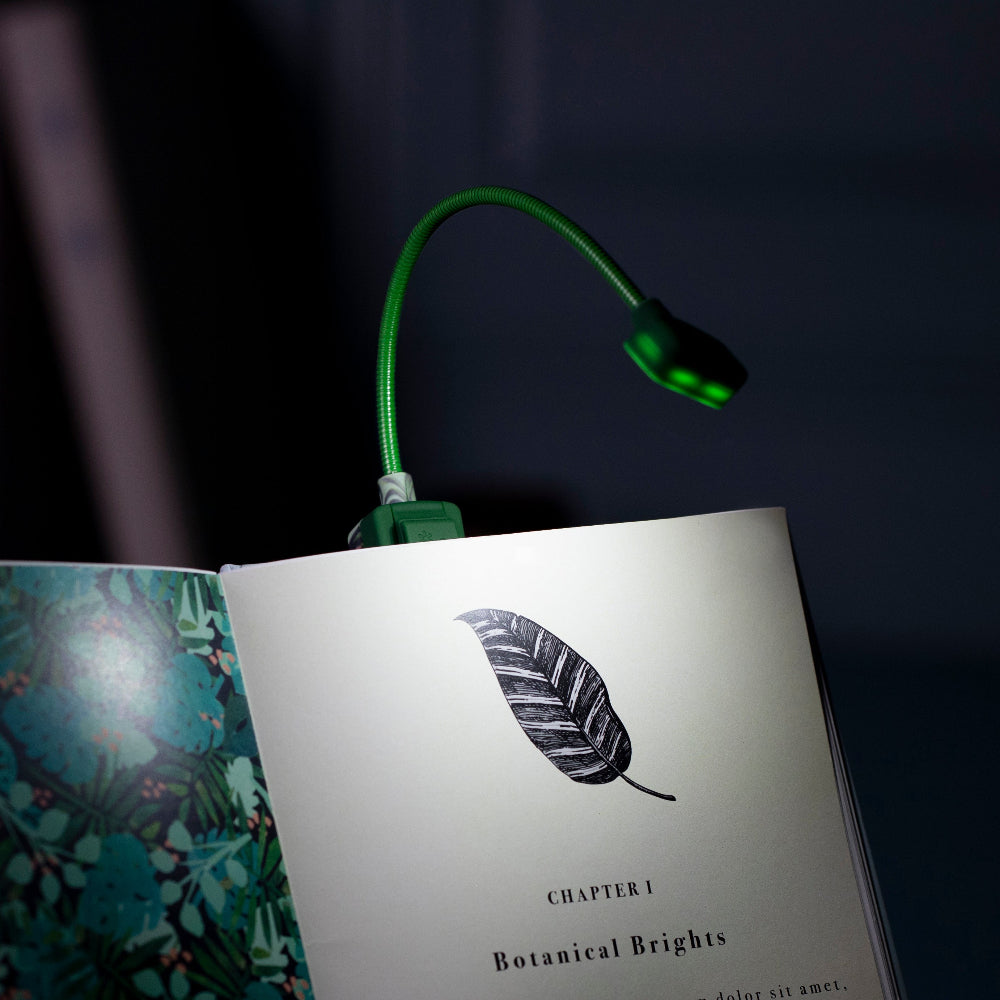 Green LED reading lamp on an open book with a leaf illustration