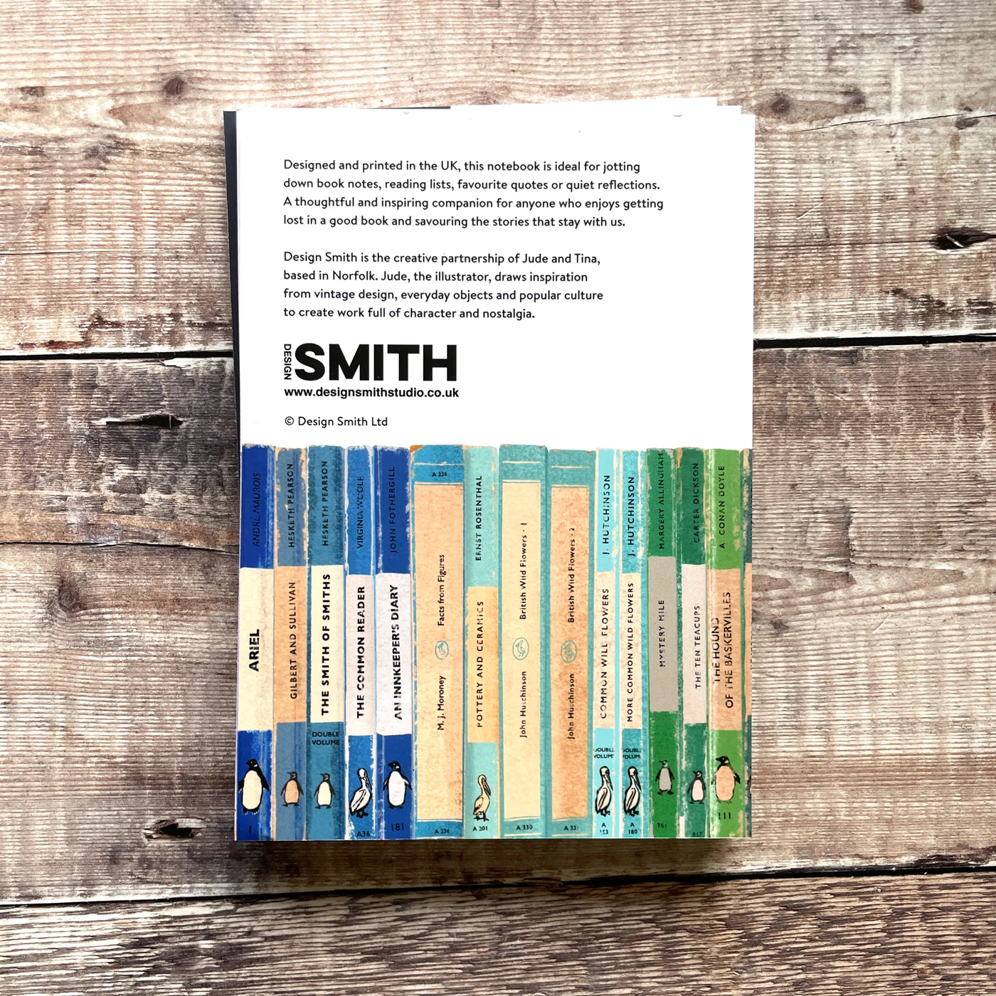 Notebook with colorful design on a wooden surface, featuring Design Smith branding.