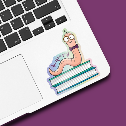 Bookworm Vinyl Sticker stuck to a laptop. Bookworm sitting on top of books.