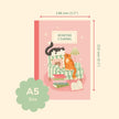 Pink reading journal with cat illustration and dimensions on a beige background