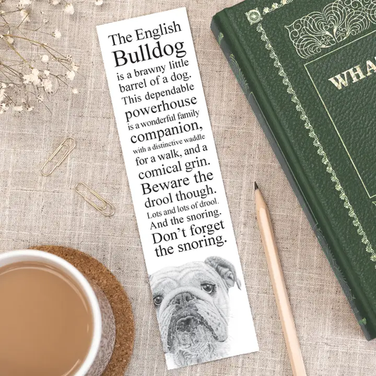 Bookmark with bulldog illustration and text on a table with a book and cup of coffee.