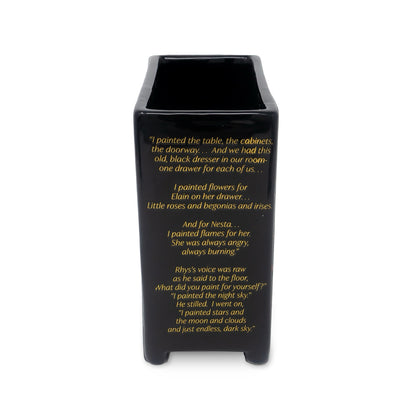 Black vase with gold text on a white background