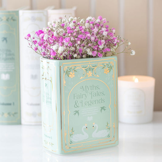 Decorative book-shaped container with flowers on a table