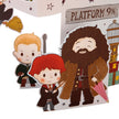 Cartoon-style cutouts of characters from a popular franchise, including a boy with red hair, a bearded man, and a sign for Platform 9 3/4.