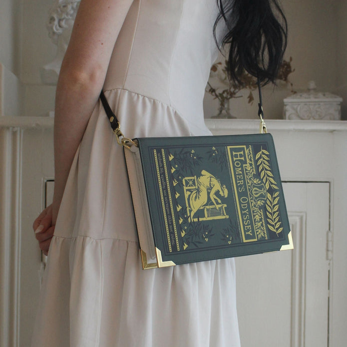 Person wearing a book-shaped handbag with decorative design