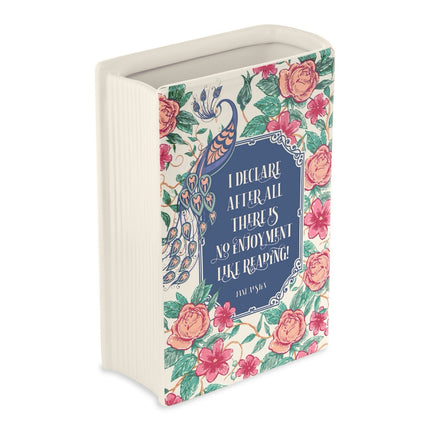 Decorative book-shaped vase with floral design and quote on a white background