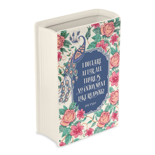 Decorative book-shaped vase with floral design and quote on a white background