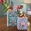 Two decorative vases with Easter-themed rabbits and tulips on a wooden surface.
