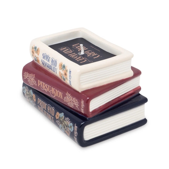 Stack of decorative books candle against a white background