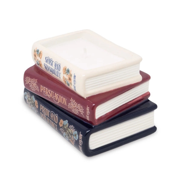 Stack of decorative books candle with visible titles on a white background