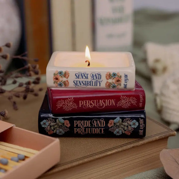 Stack of books with 'Pride and Prejudice' on top, featuring a lit candle inside.