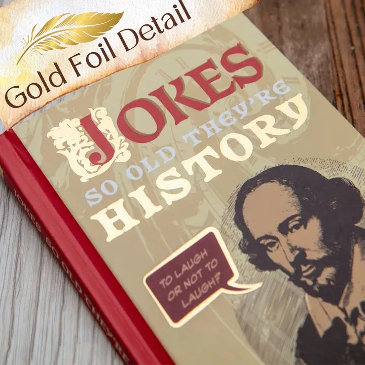 Book titled 'Jokes So Old They're History' with a gold foil detail on a wooden surface.