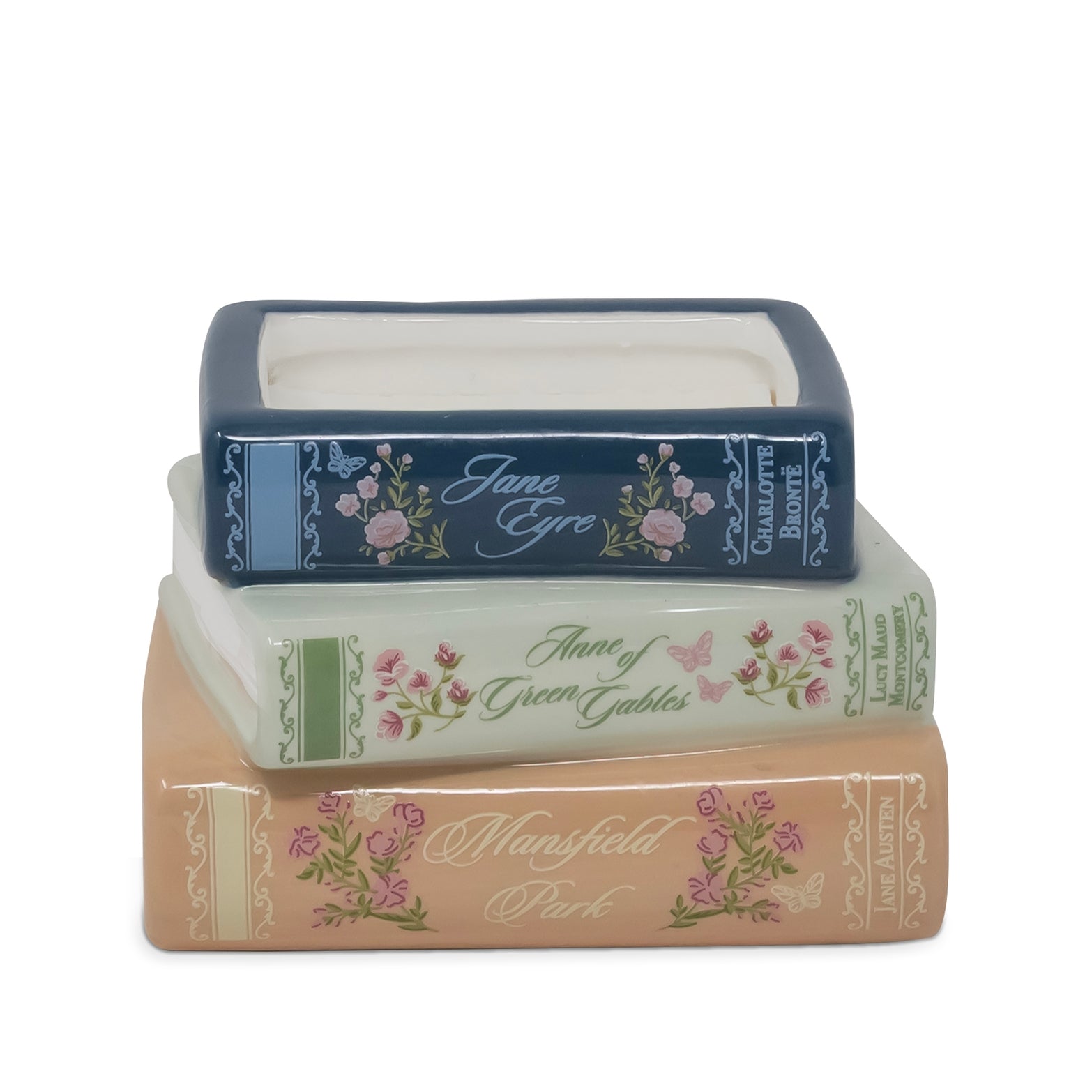 Three stacked ceramic book-shaped containers with floral designs and decorative spines, shown on a plain white background.