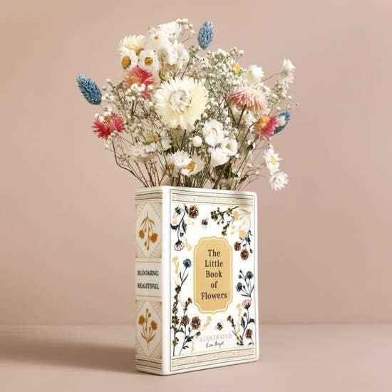 Book-shaped vase with flowers on a beige background