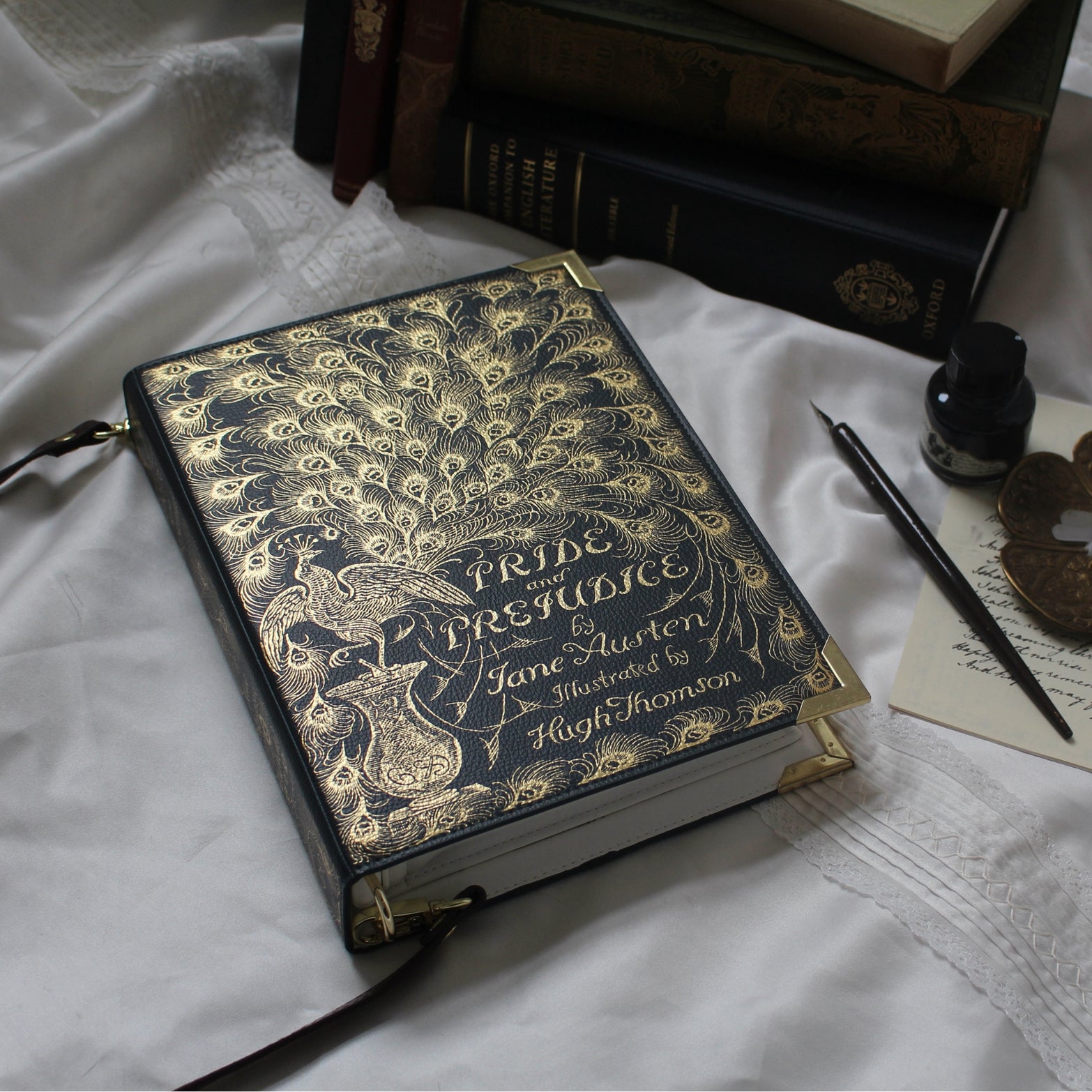 Decorative book titled 'Pride and Prejudice' with gold detailing on a white fabric background.