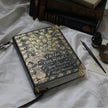 Decorative book titled 'Pride and Prejudice' with gold detailing on a white fabric background.