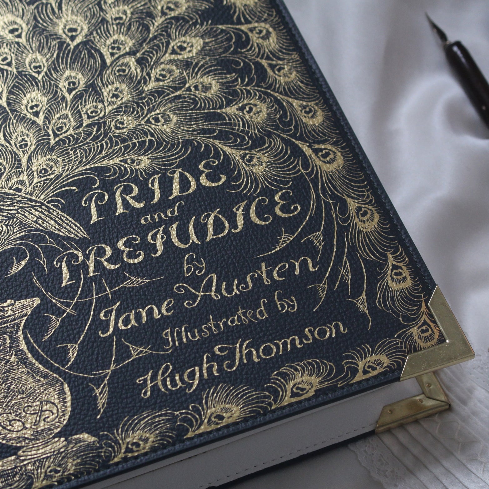 Decorative book cover of 'Pride and Prejudice' by Jane Austen with gold peacock feather design.