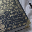Decorative book cover of 'Pride and Prejudice' by Jane Austen with gold peacock feather design.