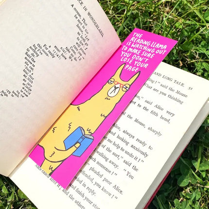 Bookmark with a cartoon llama design on an open book in grass
