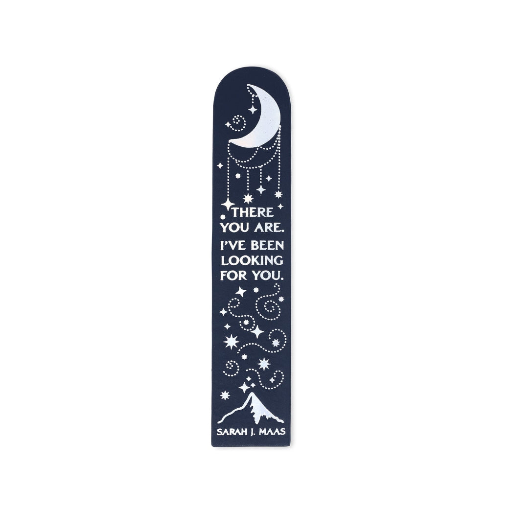 A bookmark with a navy blue background, featuring white celestial illustrations of a crescent moon, stars, and a mountain, along with the quote 'THERE YOU ARE. I'VE BEEN LOOKING FOR YOU.