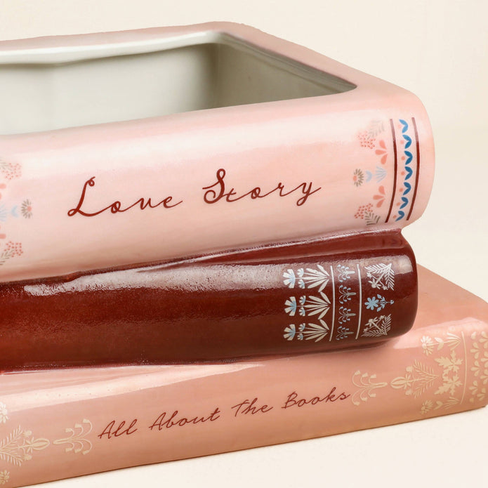 Three decorative books with text and patterns on a light background