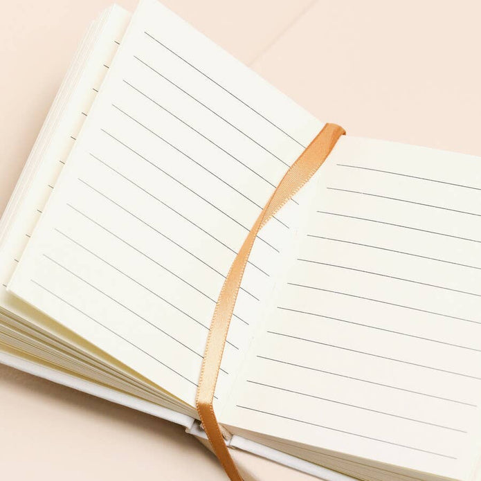 Open notebook with lined pages on a beige background