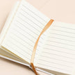 Open notebook with lined pages on a beige background