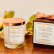 Shakespeare Candle Company candle and packaging on a wooden surface with leaves in the background