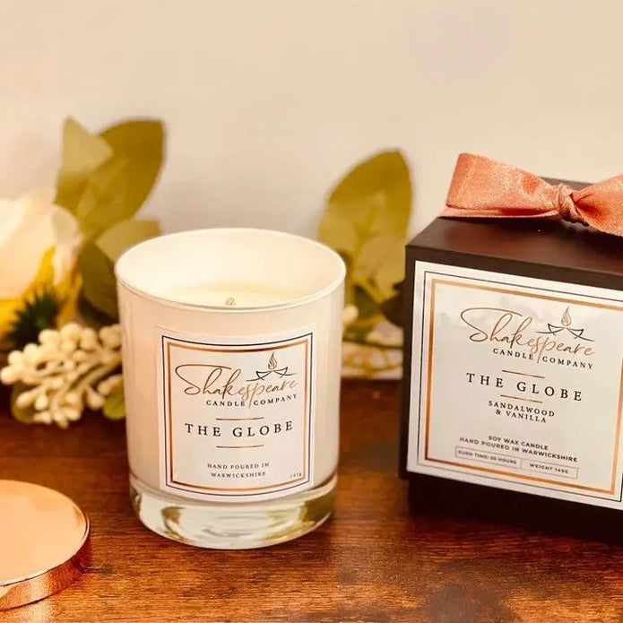 Shakespeare Candle Company candle and packaging on a wooden surface with decorative elements.