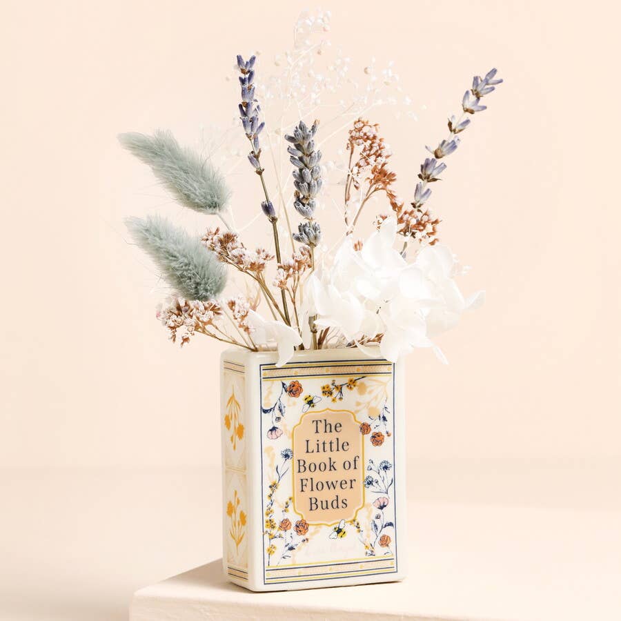 Decorative vase with dried flowers labeled 'The Little Book of Flower Buds' on a beige background