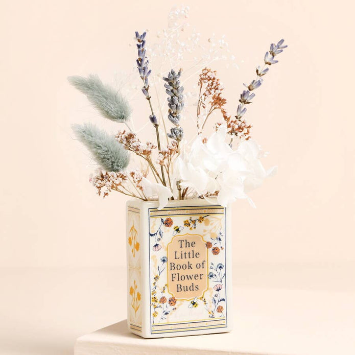 Decorative vase with dried flowers labeled 'The Little Book of Flower Buds' on a beige background
