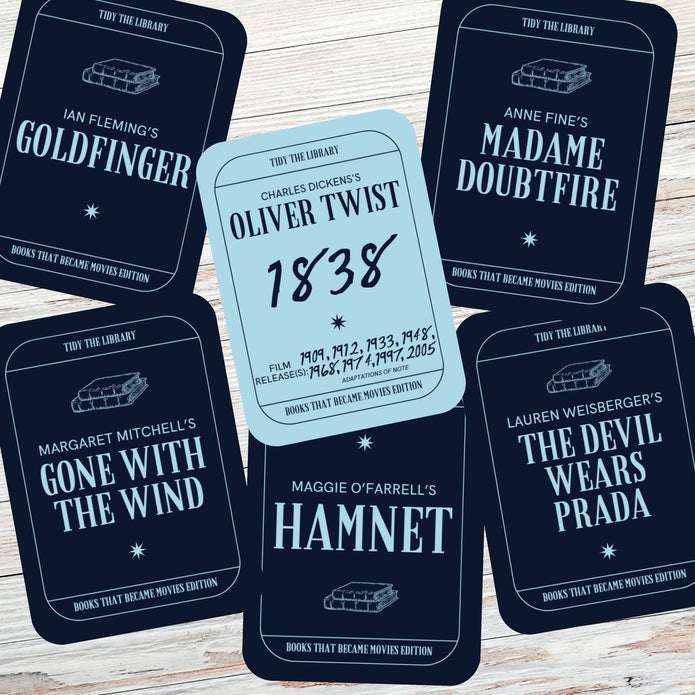 Card game pieces with book title and author text on a wooden surface