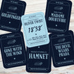 Card game pieces with book title and author text on a wooden surface