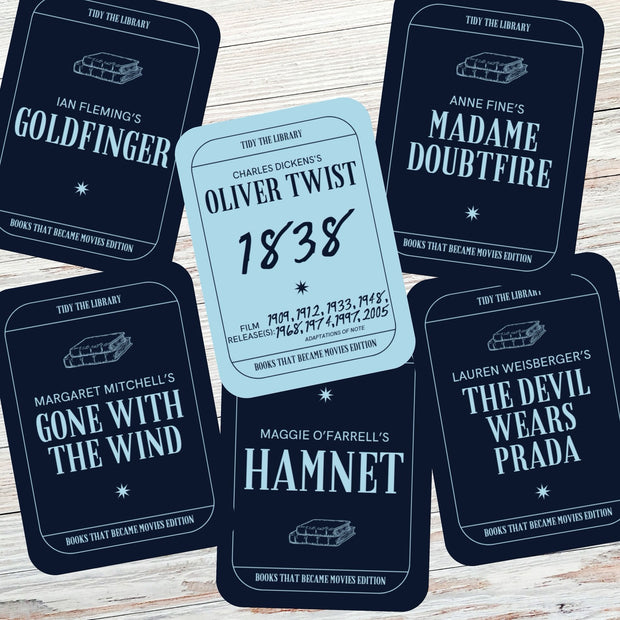 Card game pieces with book title and author text on a wooden surface