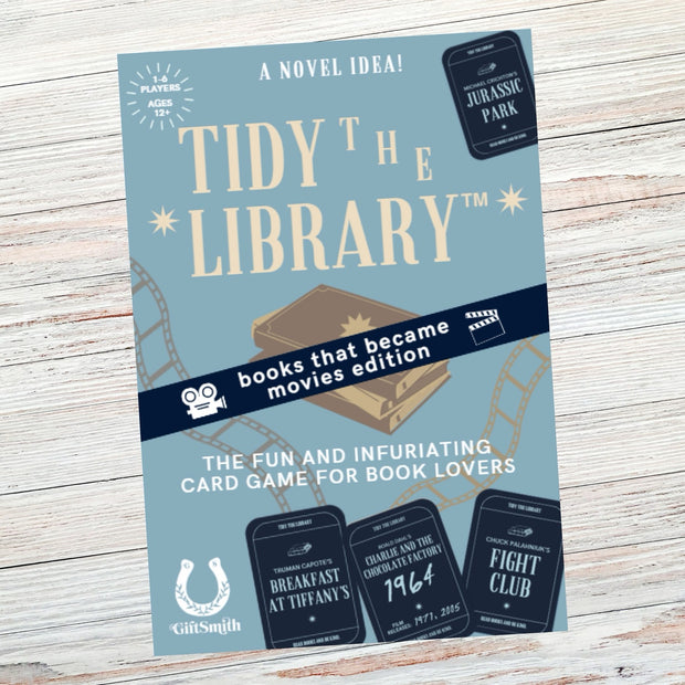 Promotional poster for 'Tidy the Library' card game on a wooden surface