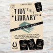 Expansion pack for a card game titled 'Tidy the Library' on a wooden surface