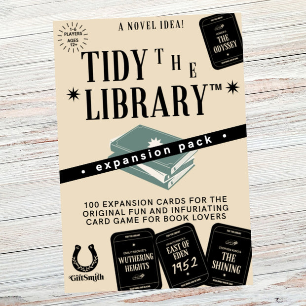 Expansion pack for a card game titled 'Tidy the Library' on a wooden surface