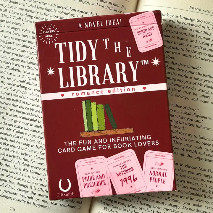 Card game box titled 'Tidy the Library' on top of a book