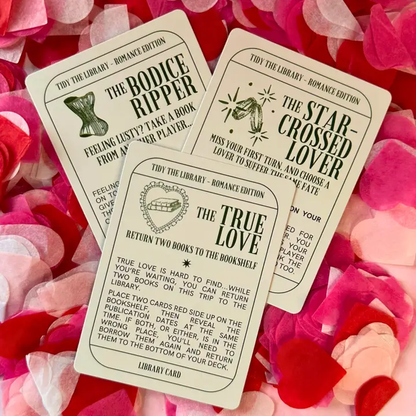 Three book-themed cards on a bed of pink and red flower petals.