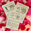 Three book-themed cards on a bed of pink and red flower petals.