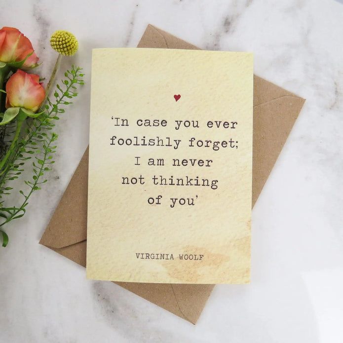 Card with a quote by Virginia Woolf on a marble surface with flowers.
