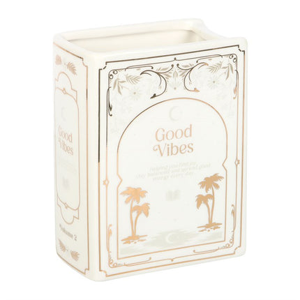 Decorative book shaped vase with 'Good Vibes' text and palm tree designs on a white background