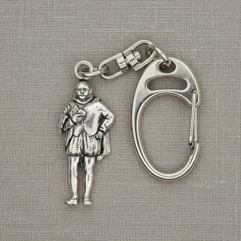 A silver-tone metal keychain featuring a detailed miniature figure of a historical man in Renaissance clothing, attached to a carabiner clip, displayed on a bright blue satin fabric background.