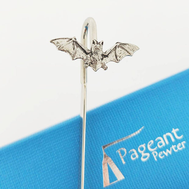 A silver bat-shaped pewter bookmark with spread wings, shown standing on a blue branded card that reads Pageant Pewter.