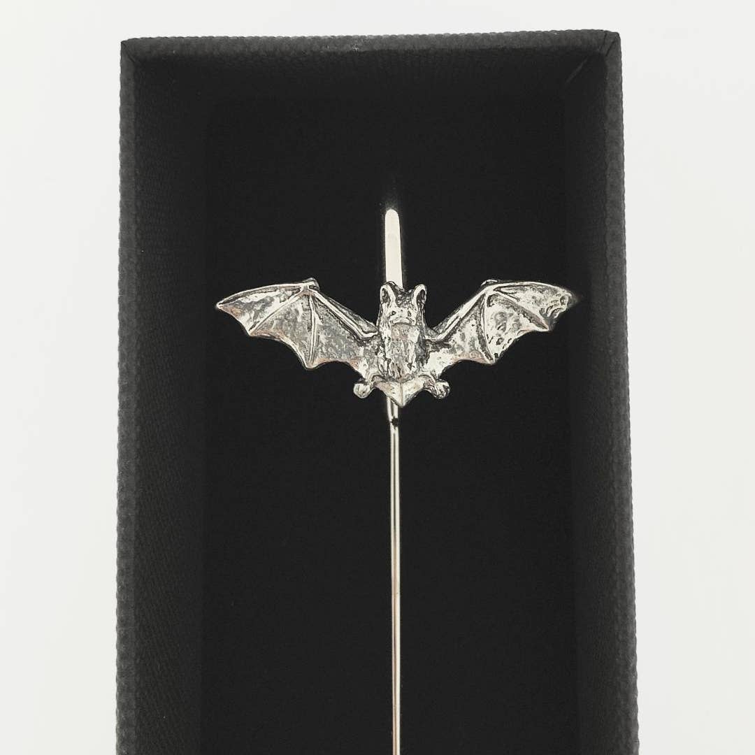 A silver bat-shaped bookmark with spread wings mounted on a straight pin, displayed inside a black presentation box against a white background.